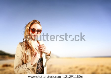 Slim young blond woman and autumn background of mountains and sea. Free space for your decoration. 