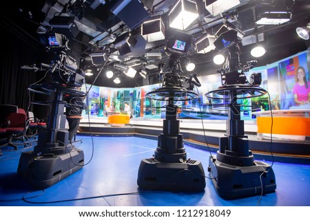 Camera in studio are broadcasting journalists reading news.Blur background have table for reporter.