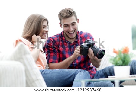 young man shows a photo of his girlfriend sitting in the living room