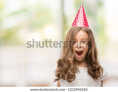 Brunette hispanic girl wearing birthday hat scared in shock with a surprise face, afraid and excited with fear expression
