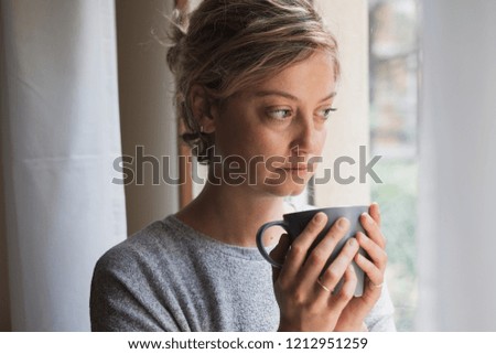 Woman feeling bad and looking for comfort and warm drinking cup of hot chocolate