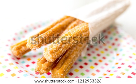 homemade churros in a plate for summer party  Royalty-Free Stock Photo #1212953326