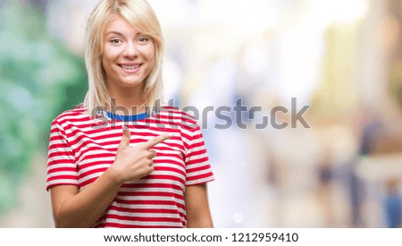 Young beautiful blonde woman over isolated background cheerful with a smile of face pointing with hand and finger up to the side with happy and natural expression on face looking at the camera.