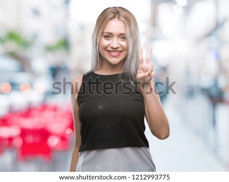 Young blonde woman over isolated background showing and pointing up with fingers number two while smiling confident and happy.