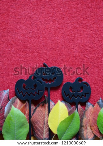 Wooden skewers in the form of a pumpkin for Halloween on a red background, Copy space