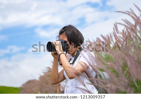 The girl is practicing professional photography while traveling on a beautiful meadow.
