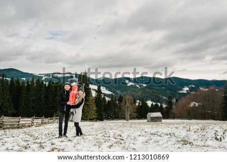 Happy family are having fun and playing on snowy winter, walk in mountain nature. Father, mother and children daughter enjoying journey. Frost winter season.