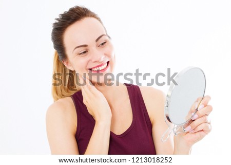 Young caucasian woman looking wrinkles on face in mirror isolated on white background. Skin care and makeup concept. Copy space
