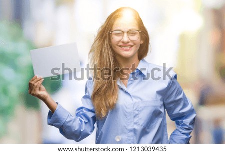 Young beautiful blonde business woman holding blank card over isolated background with a happy face standing and smiling with a confident smile showing teeth