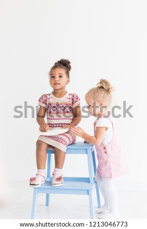 Two little girls playing on a white background