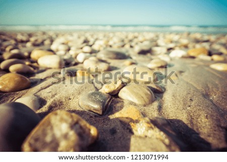 beach scene wallpaper, stones on sand with sea. Holidays concept