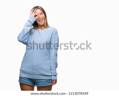 Young beautiful woman wearing winter sweater over isolated background doing ok gesture with hand smiling, eye looking through fingers with happy face.