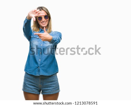 Young beautiful woman wearing sunglasses over isolated background smiling making frame with hands and fingers with happy face. Creativity and photography concept.