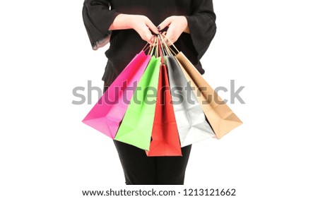 Closeup of a woman holding different color shopping bags against a white background