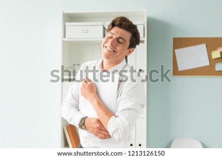 Business people, fool and joke concept - young handsome man in suit having fun in the office