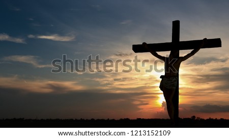 Crucifixion with Jesus against the background of the falling sun. Royalty-Free Stock Photo #1213152109
