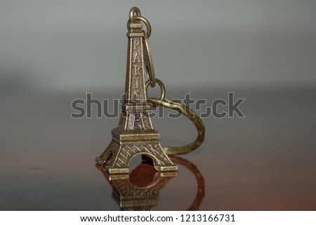Eiffel tower keyring keychain, official travel souvenir and symbol of Paris - France, isolated on wood background