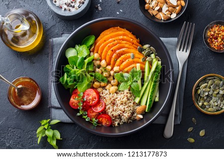 Healthy vegetarian salad. Pumpkin, quinoa, chickpea, tomatoes, green salad. Buddha bowl. Slate background. Top view. Royalty-Free Stock Photo #1213177873