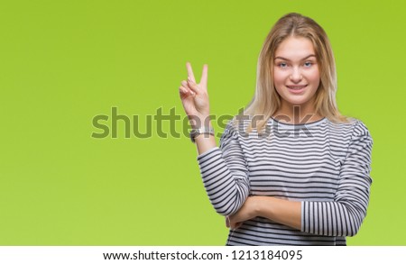 Young caucasian woman over isolated background smiling with happy face winking at the camera doing victory sign. Number two.