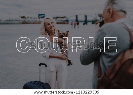 Poses. Takes Pictures. Film Camera. Love Story. Travel Bag. Interesting Trip. Little Dog. Sweet Moments. Happy Together. Old Couple. Two Pensioners. Walk. Square. Retired. Leisure Time. Have Fun.