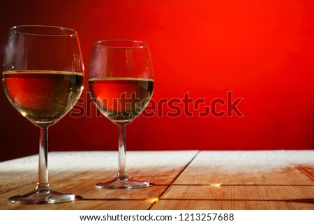 Two glasses with white wine on an old wooden table in a Christmas mood 
