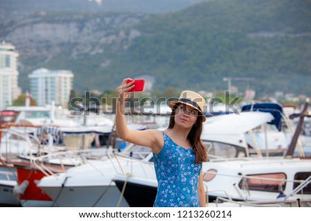 Europe travel selfie, cute happy smiling tourist girl taking self-portrait picture with smartphone during summer vacation in famous European Mediterranean destination.