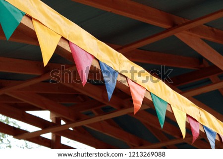 festive colored flags on a wooden beam happy holiday