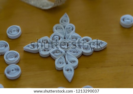 Beautiful Christmas tree decoration, white snowflake, quilling, made of thin white strips. Concept hobby, homemade decoration.