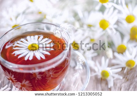 A clear Cup of medicinal chamomile tea on an old wooden table. Health and healthy lifestyle concept