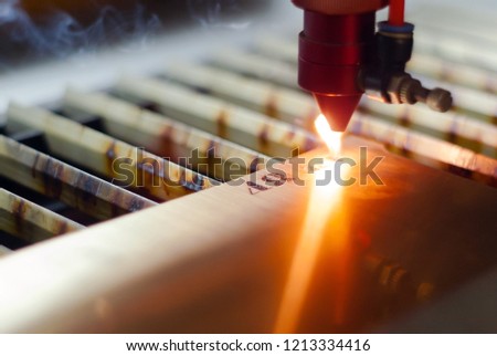 stage of manufacturing, laser engraving in automatic mode, close-up, blurred background Royalty-Free Stock Photo #1213334416