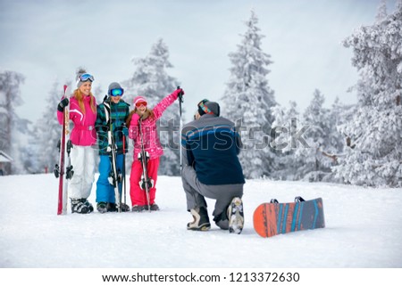 Ski, snow sun and fun - happy family on ski holiday taking picture