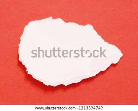 White ripped paper on red paper background. copy space