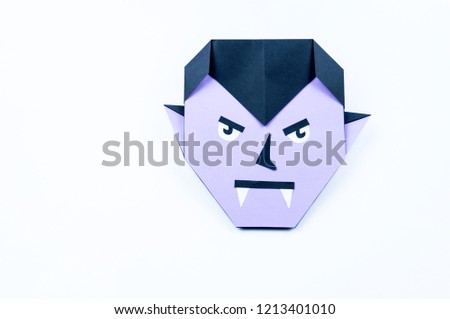 Origami Halloween. Vampire with purple skin and fangs made of paper. Copy spase