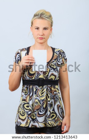 Young blonde girl casual shirt holds blank brochure, booklet, pamphlet, leaflet with copyspace