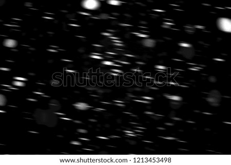 white dots snow in motion on a black background blurry