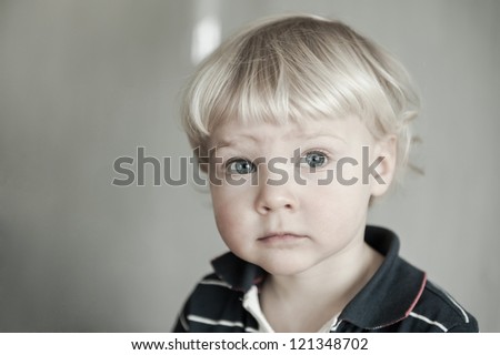 Serious blond boy with deep blue eyes
