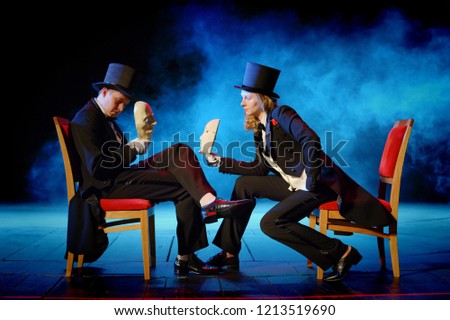 young actors in tuxedos holding theatrical masks Royalty-Free Stock Photo #1213519690