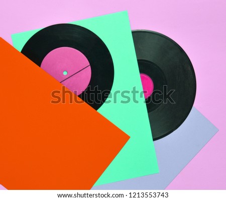 Vinyl plates on a colored pastel background. Retro musical attributes from the 80s. top view, minimalism. Copy space
