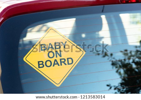 Close-up Of Yellow Baby On Board Sticker On Car Back Window