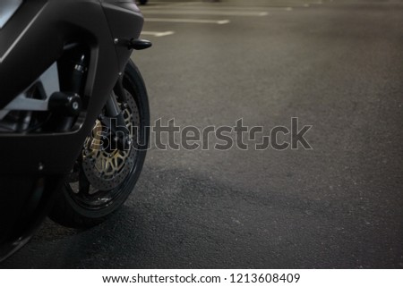 Close up cropped picture of front chrome wheel and tyre of stylish blue motorcycle on blank copyspace road. Transportation, two wheeled vehicles, motorcycling, extreme sports and adrenaline concept