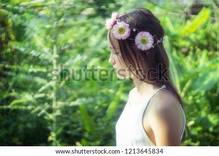 Beautiful caucasian preteen girl wearing flower wreath and white dress in forest. Fairy background. Text space 