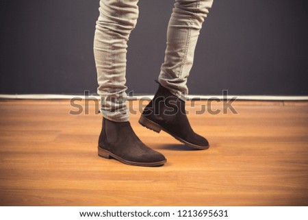 
man wearing classic male boots in black background, classic man shoes