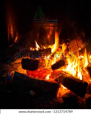 Camp fire in night with large tourist pot