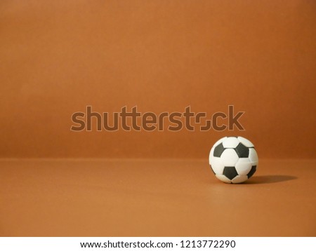 sports equipment including a american football, soccer ball, basketball and billiards on brown and yellow background. Top view