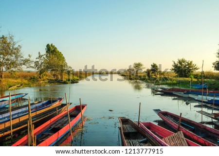 colorful fisherman boats at river dock with blue sky background. 