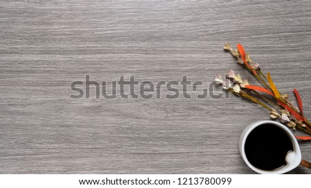 Coffee and flower flat lay on top wood counter top with blank copy space ideal for company branding message