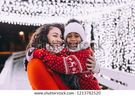 Little black girl enjoying in ice skating with her mother.