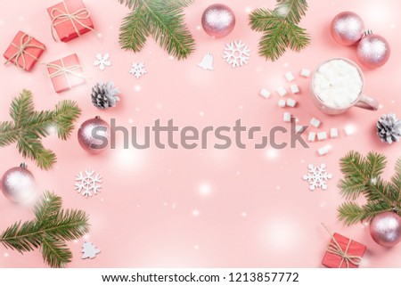 Christmas background with fir branches, lights, red giftboxes, pink decorations, hot drink with snow falling