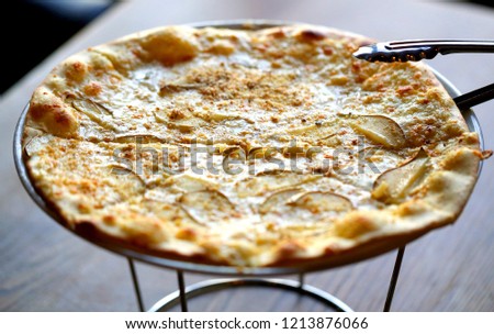 Macro photo of delicious pizza with pear and cheese on a plate in a restaurant