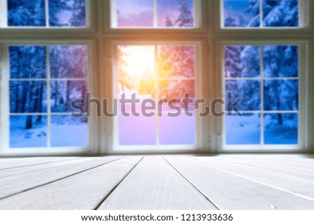 Wooden old table against the background of the window in winter sunset